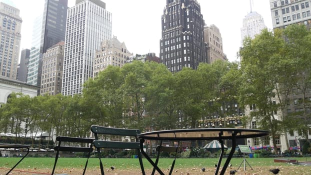 New York City, United States - 13 Sept 2023: Manhattan Midtown Bryant Park with Public library, 42 street and Fifth 5 avenue. USA landmark. Empty chair and table in summer greenery. Green grass lawn.