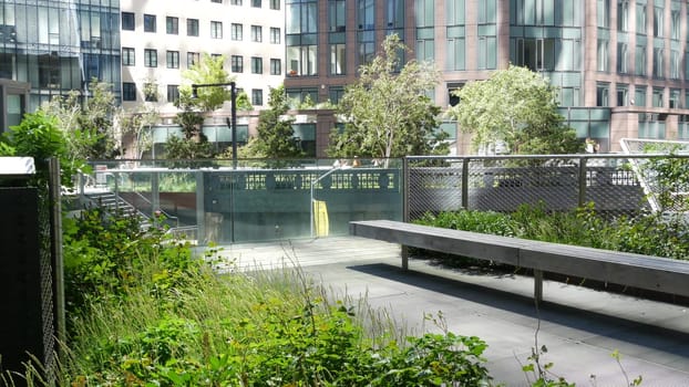 New York City, United States - 1 Sept 2023: High Line elevated greenway, Manhattan Midtown, USA. People in park. Promenade in garden greenery. American street life, Chelsea Hudson Yards. Wooden bench.