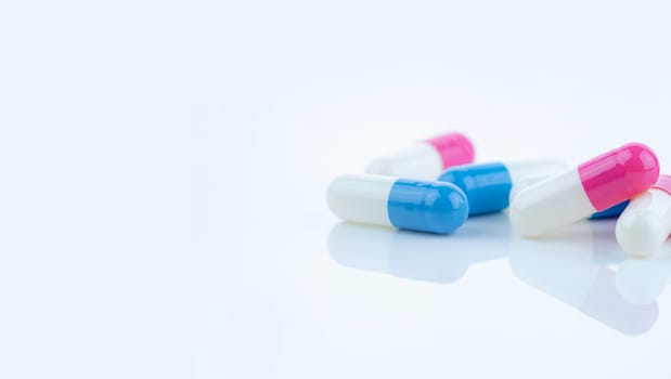 Blue and pink capsule pills spread on white background, showcasing pharmaceutical products, healthcare concepts, and the role of prescription medicine in advancing treatment and patient well-being.