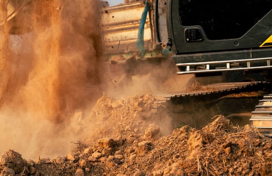 Close-up of excavator at construction site. Backhoe digging soil for earthwork and construction business. Excavating machine at work. Heavy machinery for earth moving and construction site development