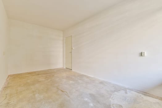 An empty, minimalist interior space featuring a bare wall and natural lighting, creating an open and airy atmosphere suitable for various uses.