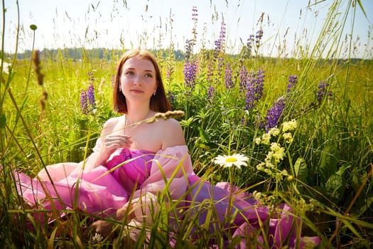 Woman in a vibrant dress relaxes on a sunny day amid blooming wildflowers in a serene field, enjoying nature's beauty.
