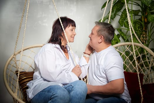 A middle-aged couple shares a tender moment indoors, embracing in a cozy atmosphere filled with love and happiness during their photoshoot.