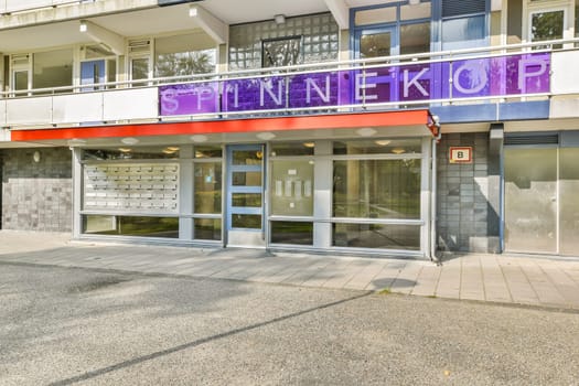 A contemporary structure featuring bold purple signage. The setting suggests a blend of urban design and functional architecture, inviting exploration.