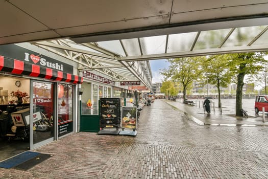A charming sushi shop with an open storefront, surrounded by trees and urban surroundings, adds a vibrant touch to the city environment.