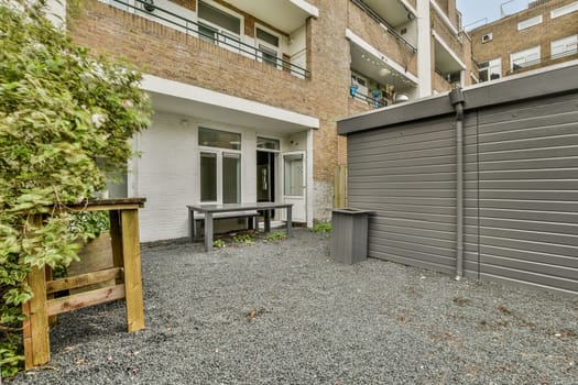 A contemporary urban setting featuring a stylish patio area with table and chairs, surrounded by an attractive minimalist courtyard and modern architecture.