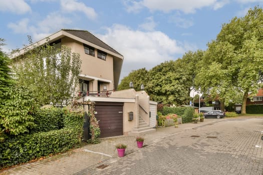 A contemporary home featuring a well-maintained garden and driveway, situated in a serene suburban neighborhood with lush greenery.