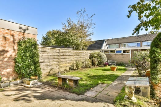 An inviting garden featuring stone benches, lush greenery, and a peaceful pathway, perfect for relaxation and enjoying nature's beauty.