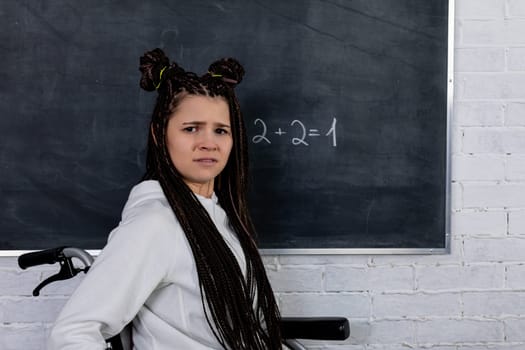 A confident young woman with stylish braids looks at the camera in a vibrant classroom by a chalkboard