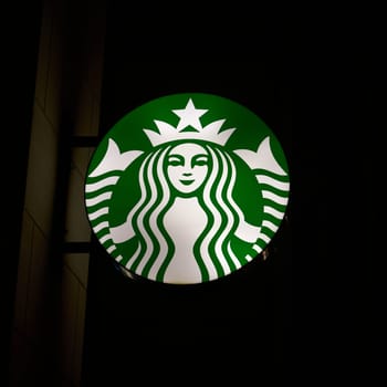 Dresden, Germany – January 17, 2025: Neon sign for the global coffee house chain Starbucks in the city center of Dresden at Night