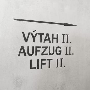 Directional arrow pointing to an elevator in Czech, German and English language