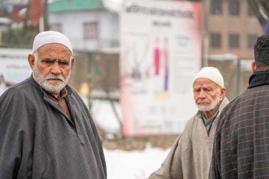 Srinagar, Kashmir - 4th Jan 2025: Group of elderly men walking along a street and looking at the passerby in Kashmir India