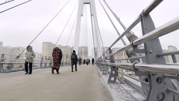 Citizens crossing a cable stayed bridge in a residential district