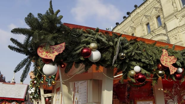 Christmas garland with red and white baubles and wooden birds decorating a market stall in red square, moscow