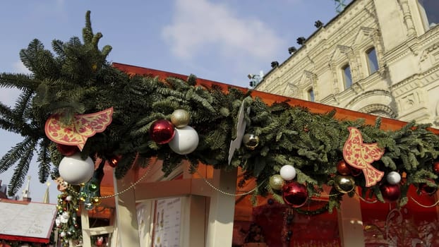 Christmas garland with red and white baubles and wooden birds decorating a market stall in red square, moscow