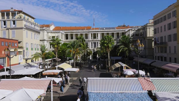 Cours saleya market, located in the heart of vieux nice, offers a vibrant atmosphere with colorful awnings, palm trees, and bustling shoppers