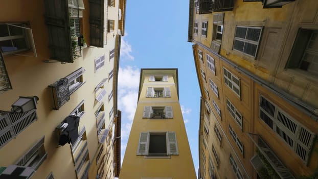Venice, Italy - July, 2024: Buildings rising towards blue sky in narrow street of nice, France