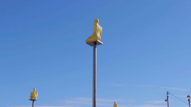 Golden statues sitting on poles against a clear blue sky