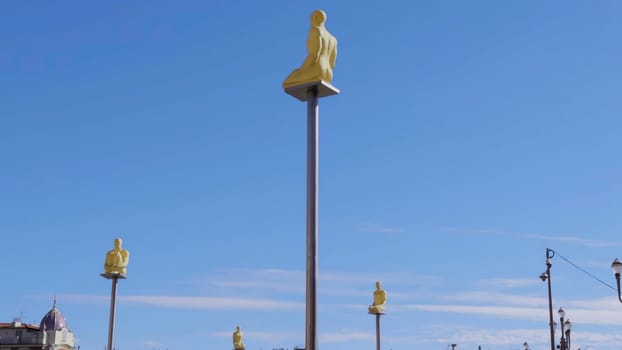 Golden statues sitting on poles against a clear blue sky