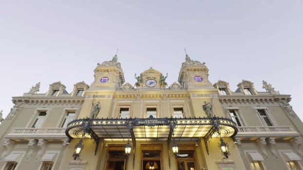 Elegant casino de monte carlo welcomes visitors with illuminated facade at twilight