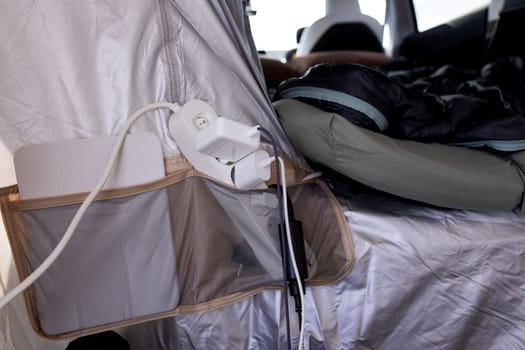 Camping tent interior with charging station and sleeping bag setup.