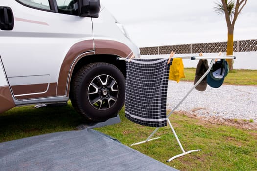 Camper van exterior with drying laundry on rack outdoors in campsite.