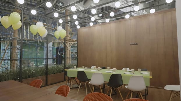 A stylish dining area decorated with colorful balloons and lush greenery, ideal for cheerful gatherings. Creative