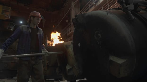 A dedicated worker in a foundry engages in the steel manufacturing process, showcasing industrial skill. Stock Clip