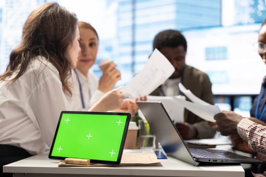 Forecast affiliates working on business expansion plans with isolated mockup screen, analyzing reports and sales infographics during a corporate meeting. Company experts reviewing statistics.