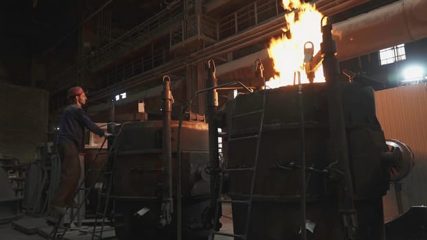 An industrial scene showcasing metalworking processes with intense flames erupting from the furnaces. Stock Clip