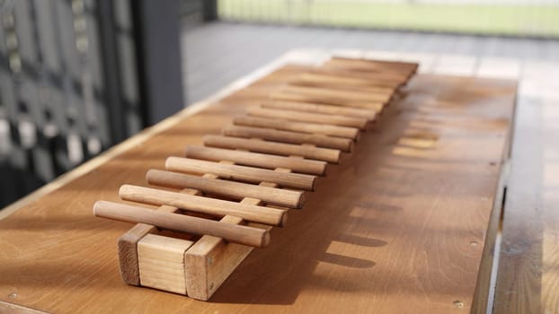 A wooden instrument with elongated bars resting on a table, perfect for aesthetic and musical compositions. Creative