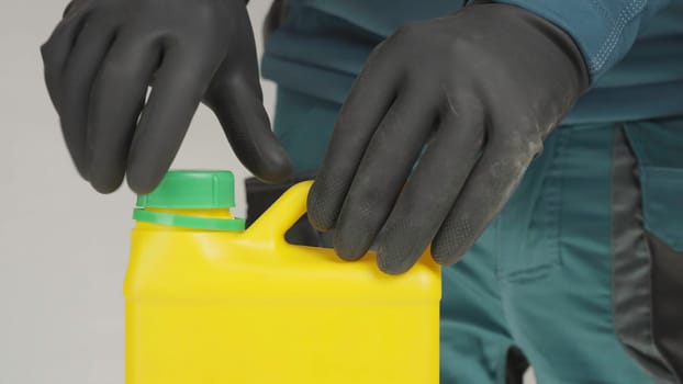 A mysterious figure in black gloves opens a yellow container, revealing hidden contents. Another gloved individual joins, intensifying intrigue. Creative