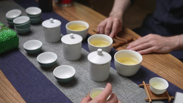 A beautifully serene tea brewing scene that showcases traditional ceramics and the meticulousness of preparation. Media