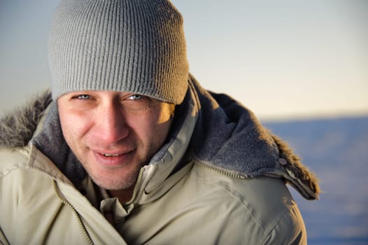 Portrait of man in warm gray jacket and hat. Closeup.