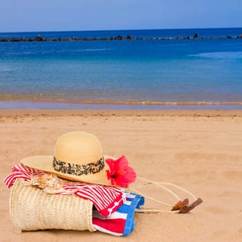 sunbathing accessories on sandy beach by the ocean