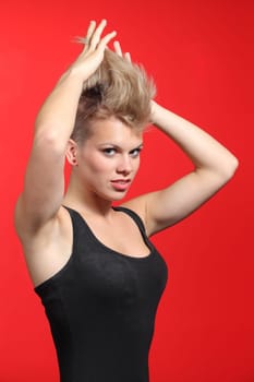 Fashion woman stretching her punk style hair on a red background