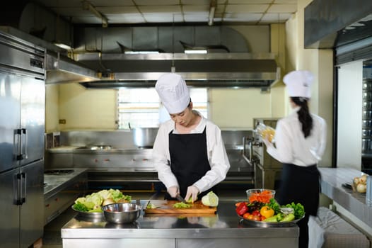 Culinary student practicing vegetable cutting skills in a professional kitchen.