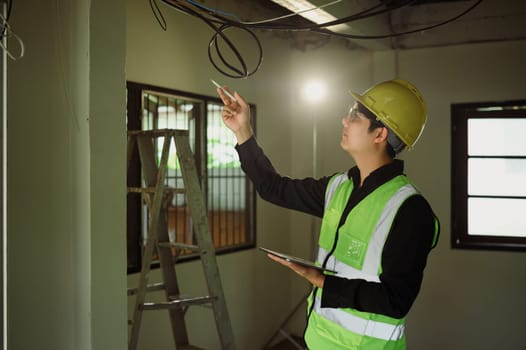 Construction supervisor inspecting electrical cables during a building renovation.