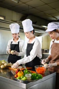 Cooking instructor demonstrating slicing techniques to students during culinary class.