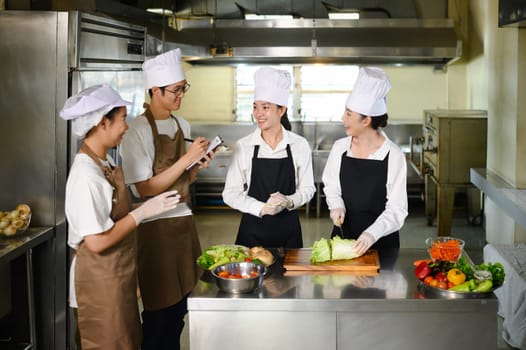 Cooking instructor guiding students in vegetable preparation during hands on class.