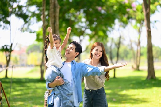 Loving Asian family enjoying carefree moments together in the park.