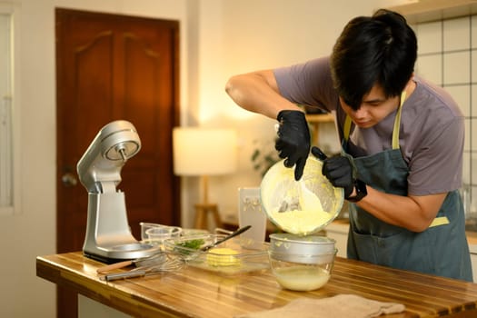 Man carefully straining fresh buttermilk from homemade butter.