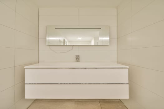 Featuring a sleek white vanity and large mirror, this bathroom embodies minimalist elegance with clean lines and a bright atmosphere.