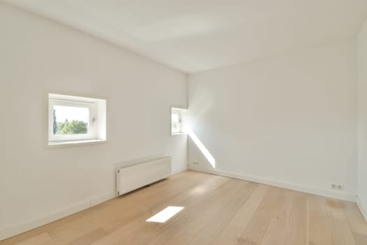 A spacious, bright empty room featuring large windows and wooden flooring, showcasing a minimalist design aesthetic. Perfect for showcasing interior concepts.