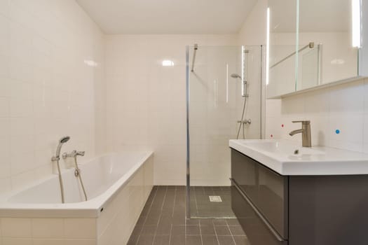 This contemporary bathroom features a sleek design with a glass shower, elegant fixtures, and a spacious bathtub complemented by clean lines and neutral colors.