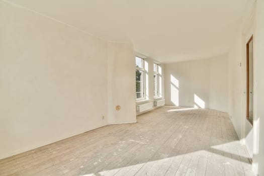 A spacious, minimalist room filled with natural light, showcasing clean lines and a serene atmosphere. Features large windows and wooden flooring for added warmth.