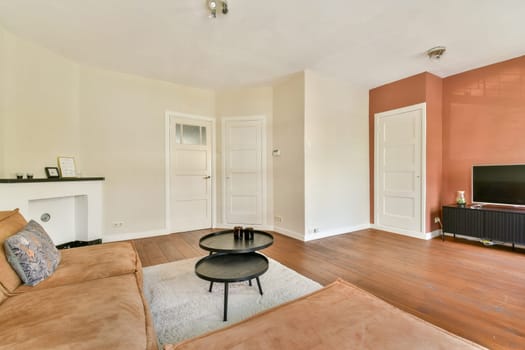 A spacious modern living room featuring a cozy couch, artistic decor, and elegant flooring, designed for comfort and sophistication.