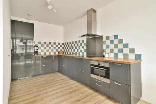 A sleek modern kitchen featuring stylish cabinets, minimalist design, and a striking backsplash that enhances the contemporary aesthetic. Ideal for culinary enthusiasts.
