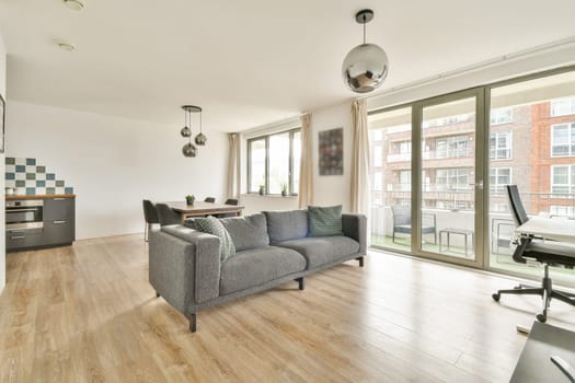 A stylish contemporary living room featuring large windows, comfortable seating, and modern decor elements, creating a bright and inviting atmosphere.