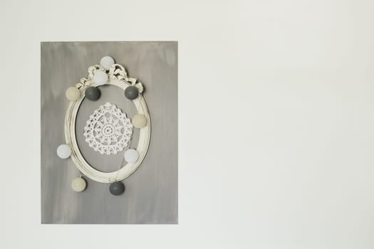 Crocheted napkins hang in a frame on the wall Village style